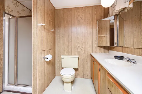 a bathroom with a sink a toilet and shower