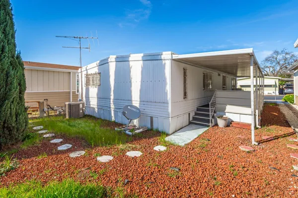 a view of a house with backyard and sitting area