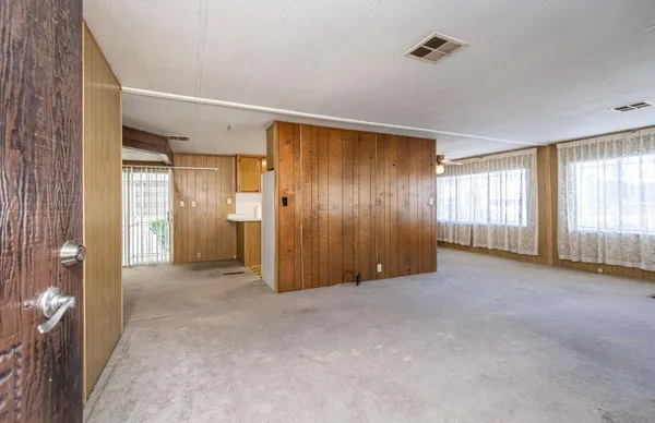 an empty room with windows and closet