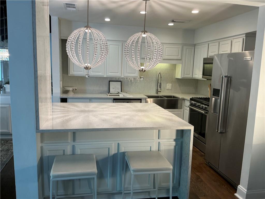 3823 Paces Ferry West Atlanta, GA 30339 - Photo 7 of 33 a kitchen with kitchen island granite countertop a sink a refrigerator and a fireplace