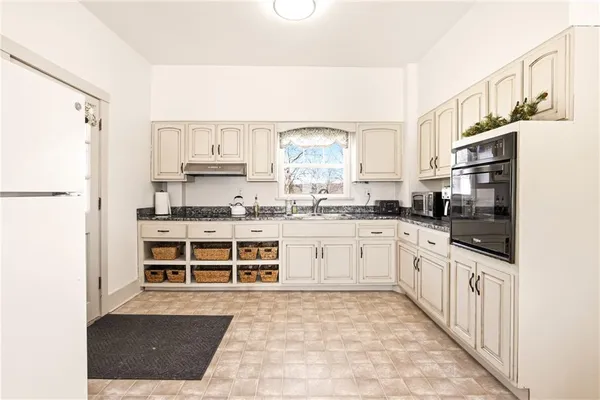 a kitchen with stainless steel appliances a refrigerator sink and cabinets
