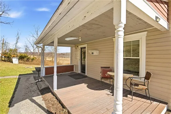 a view of a patio with table and chairs with wooden floor and fence