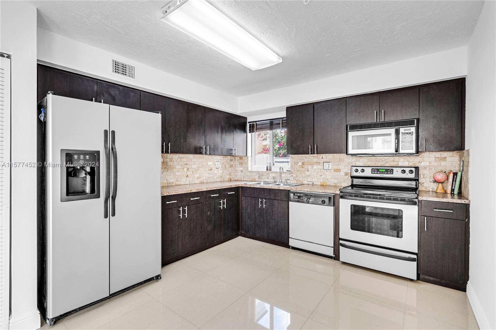 a kitchen with stainless steel appliances granite countertop a refrigerator stove a sink and dishwasher