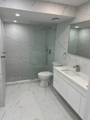 a bathroom with a sink mirror vanity and toilet