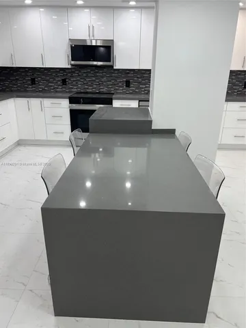 a kitchen with stainless steel appliances granite countertop a refrigerator and a stove top oven