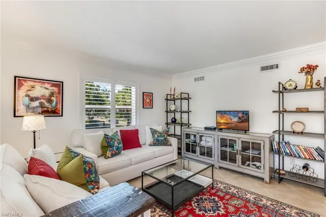 a living room with furniture a rug and a window
