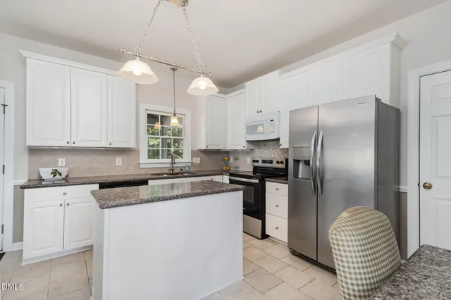 a living room with furniture a fireplace and a large window