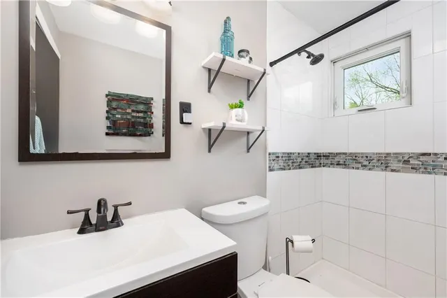 a bathroom with a sink a toilet and mirror