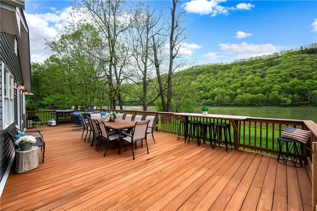 a view of a roof deck with table and chairs couches and wooden floor