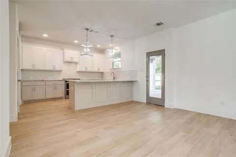 a view of a kitchen with a sink wooden cabinets and a window