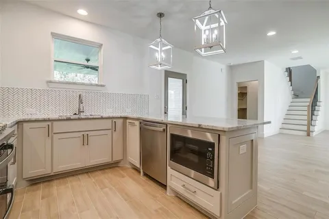 a kitchen with stainless steel appliances granite countertop a stove a sink and a microwave