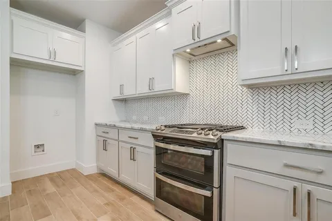 a kitchen with granite countertop cabinets stainless steel appliances and wooden floor