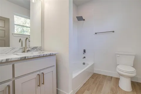 a bathroom with a sink toilet vanity and bathtub