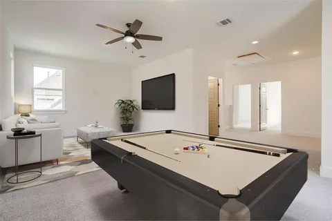 a living room with table flat screen tv and a window