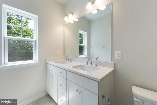 a bathroom with a shower sink vanity mirror and toilet