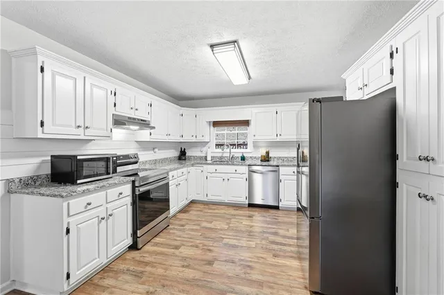 a kitchen with white cabinets and white appliances