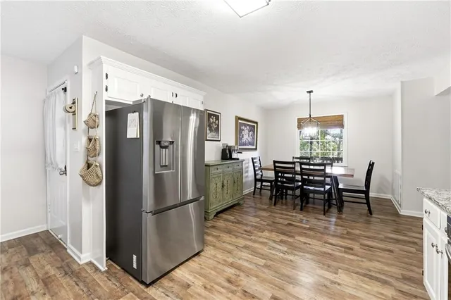 a kitchen with stainless steel appliances a refrigerator and a dining table