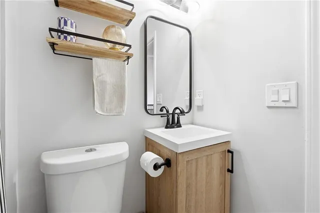 a bathroom with a sink a toilet and a mirror