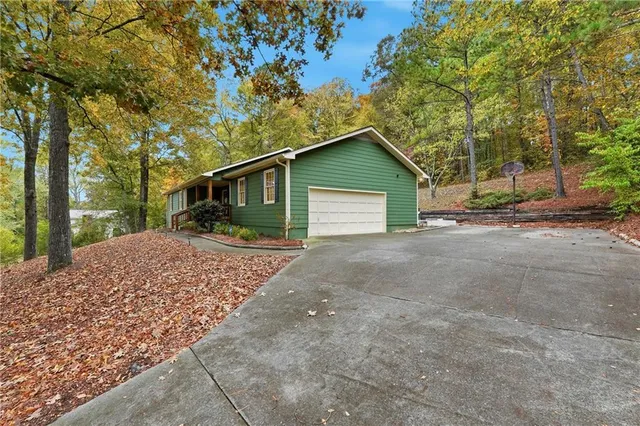 a view of a house with a yard and large trees