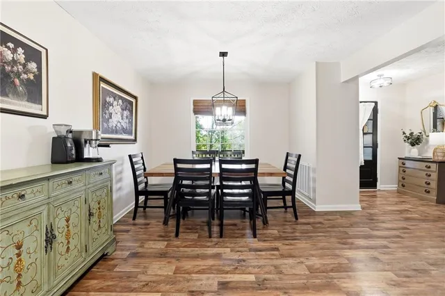a dining room with furniture a chandelier and wooden floor