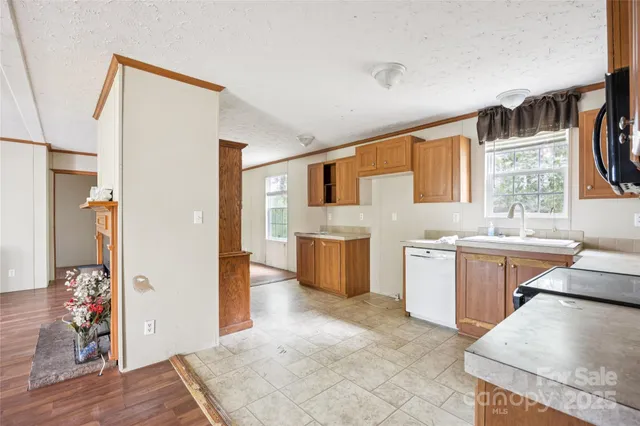 a large white kitchen with stainless steel appliances kitchen island granite countertop a refrigerator and a stove top oven
