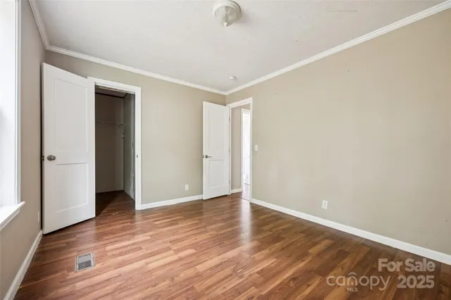 a view of an empty room with wooden floor