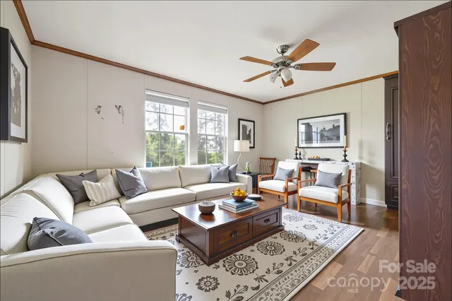 a living room with furniture ceiling fan and a window