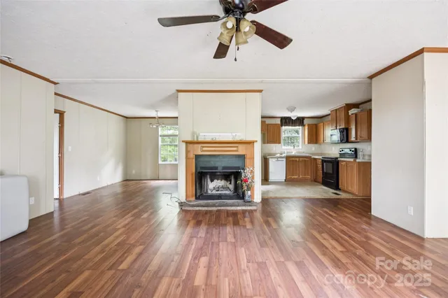 a view of a room with wooden floor a fireplace and window