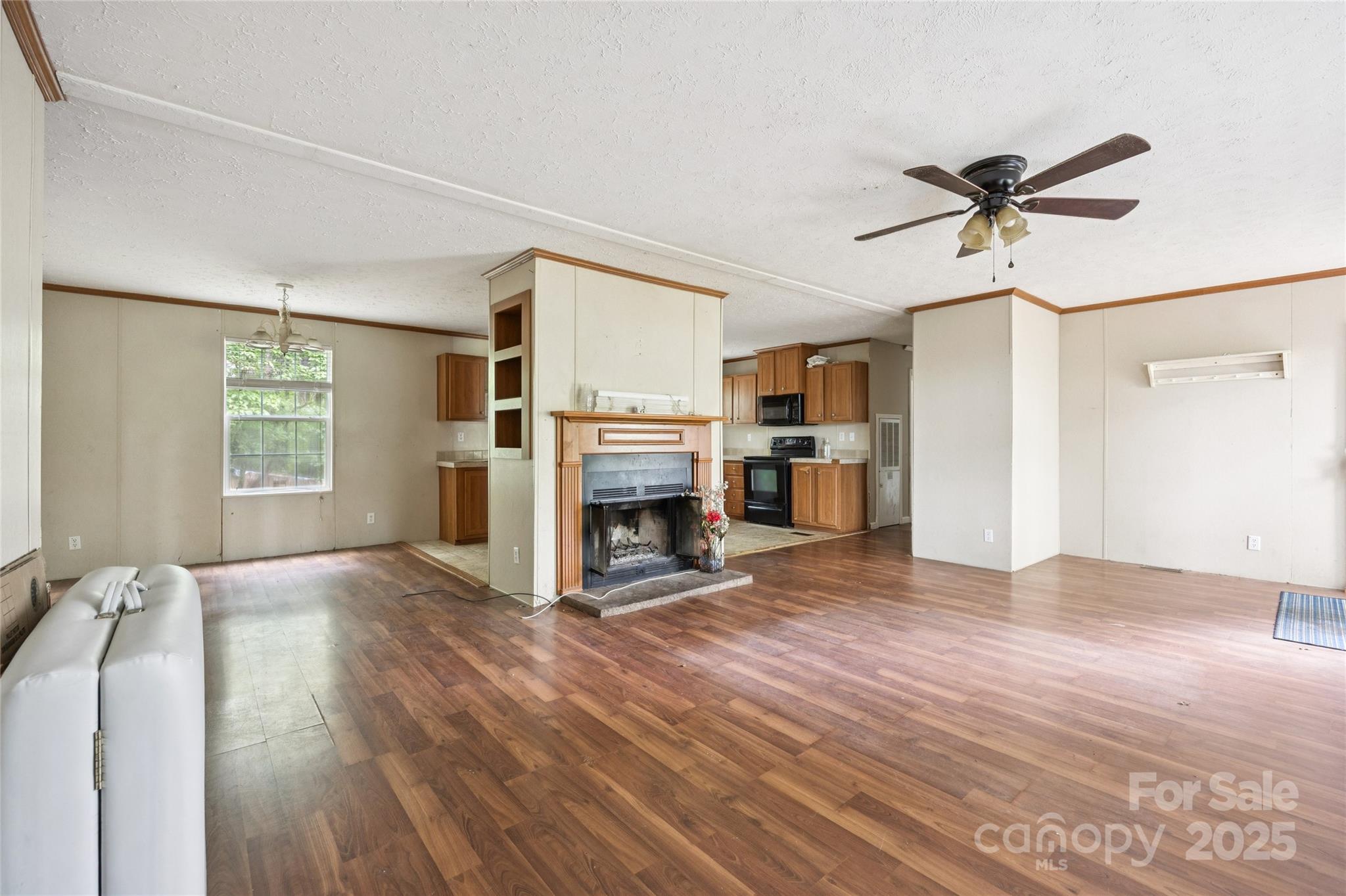 4066 General Howe Road Riegelwood, NC 28456 - Photo 6 of 27 a view of a livingroom with a fireplace a ceiling fan and windows