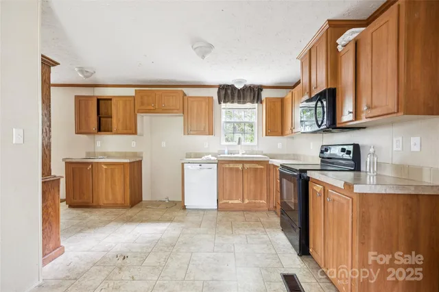a kitchen with stainless steel appliances granite countertop a stove a sink and a microwave