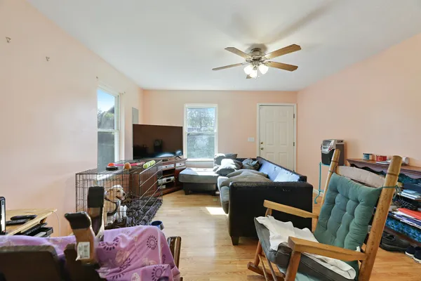 a kitchen with granite countertop a refrigerator a stove a sink dishwasher a dining table and chairs with wooden floor