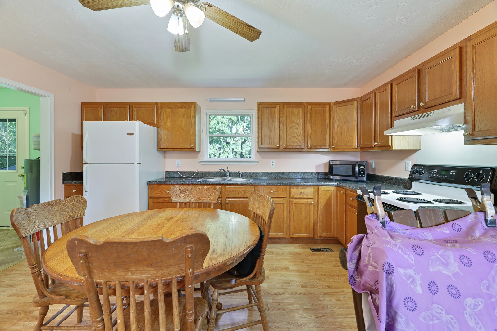 634 Bennett Hill Road Red Boiling Springs, TN 37150 - Photo 10 of 44 a kitchen with stainless steel appliances granite countertop a sink dishwasher a stove a refrigerator with a dining table and chairs with wooden floor