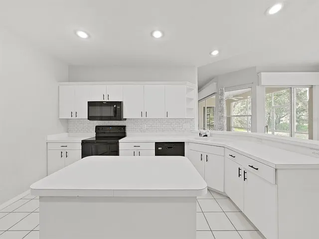 a kitchen with stainless steel appliances a white stove top oven sink and cabinets