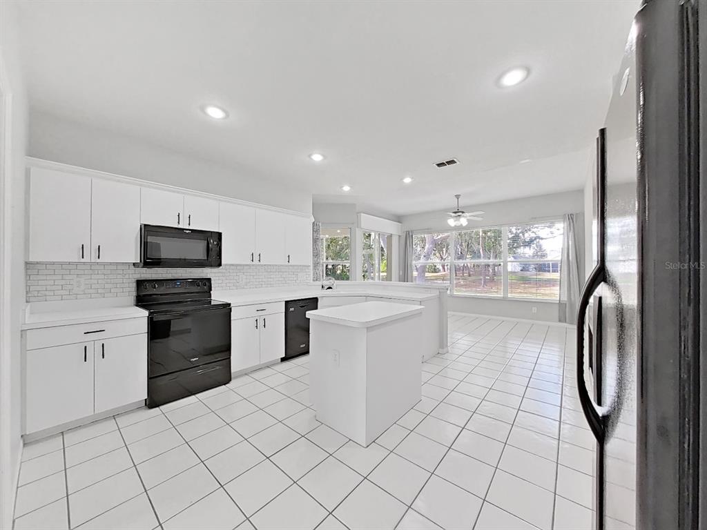 3307 Kilmer Place Plant City, FL 33566 - Photo 12 of 32 a kitchen with white cabinets and stainless steel appliances