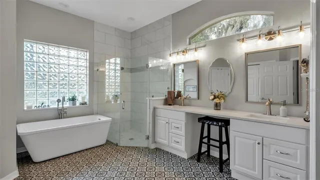 a bathroom with a double vanity sink a mirror and a bathtub