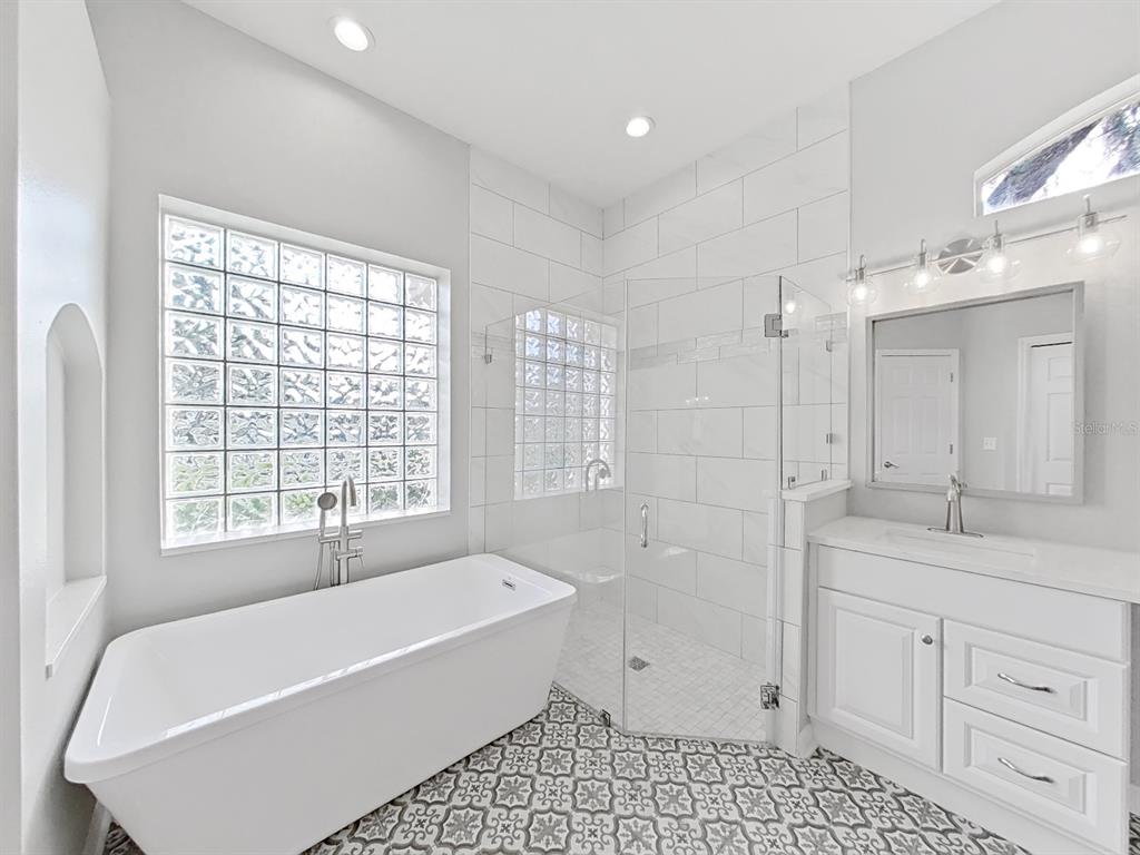 3307 Kilmer Place Plant City, FL 33566 - Photo 19 of 32 a bathroom with a bathtub a sink a vanity and a shower
