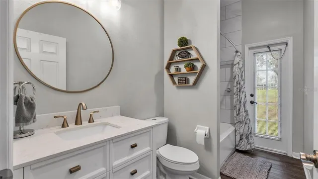 a bathroom with a toilet sink vanity and mirror