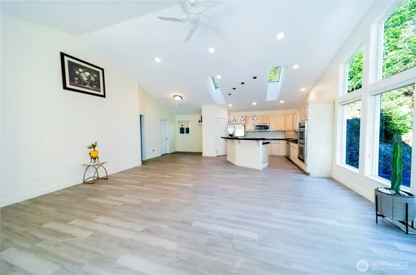 an empty room with wooden floor and large windows