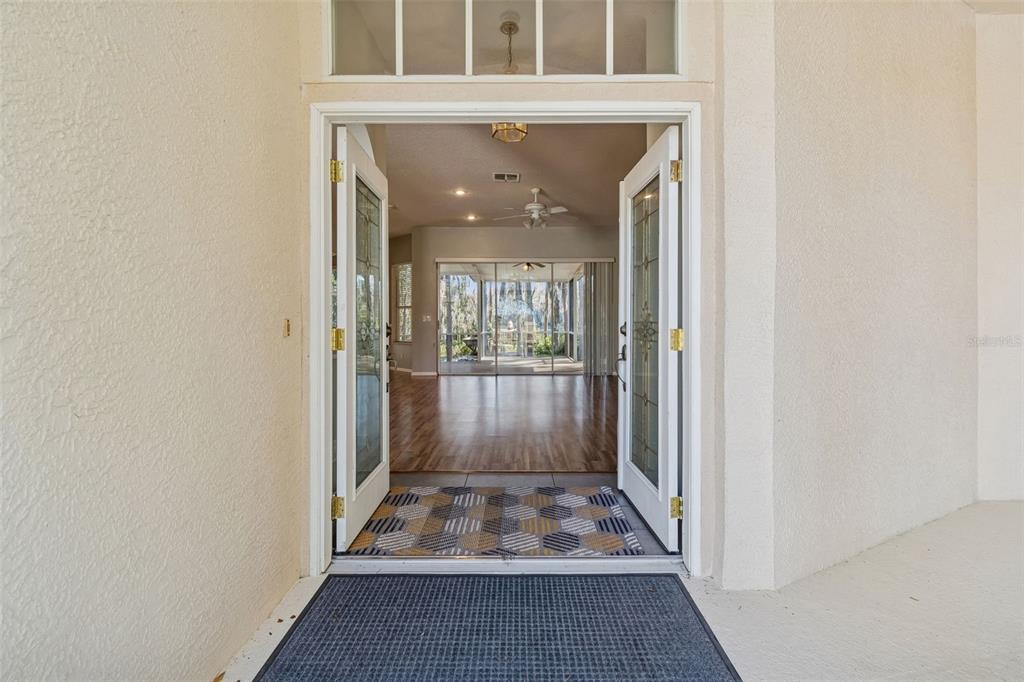 6070 Drexel Road Land O' Lakes, FL 34638 - Photo 3 of 23 a view of a hallway with wooden floor and a dining room