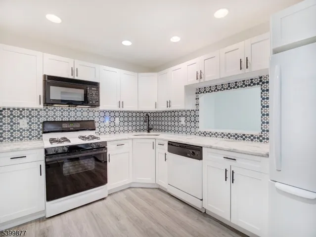 a kitchen with granite countertop white cabinets and white appliances