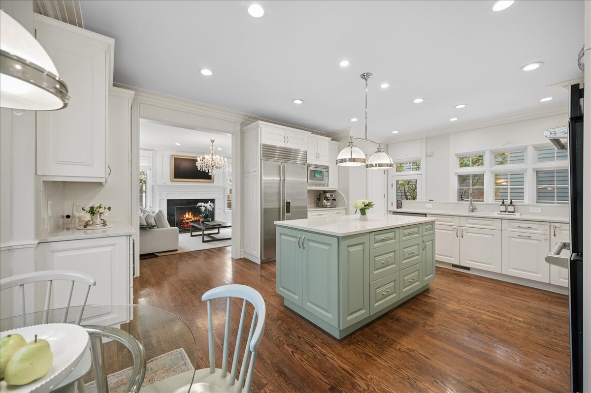 556 Willow Road Winnetka, IL 60093 - Photo 11 of 43 a kitchen with kitchen island granite countertop a sink cabinets and wooden floor
