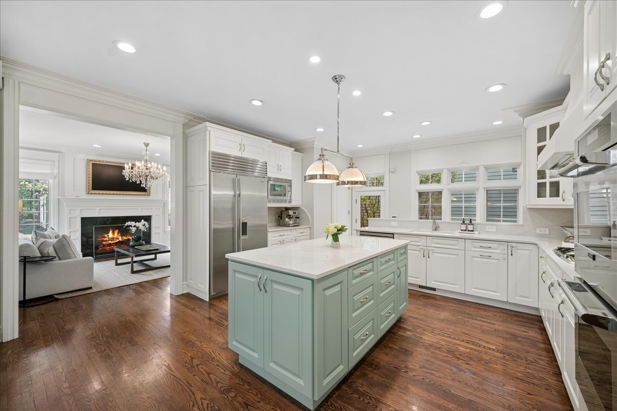 556 Willow Road Winnetka, IL 60093 - Photo 12 of 43 a large kitchen with stainless steel appliances granite countertop a stove and a wooden floors