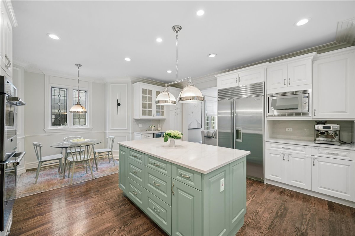556 Willow Road Winnetka, IL 60093 - Photo 15 of 43 a kitchen with kitchen island a sink stainless steel appliances and wooden floor