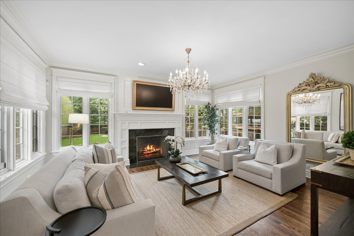 556 Willow Road Winnetka, IL 60093 - Photo 18 of 43 a living room with furniture a chandelier and a fireplace
