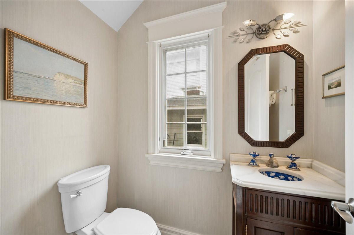 556 Willow Road Winnetka, IL 60093 - Photo 21 of 43 a bathroom with a toilet a sink and mirror