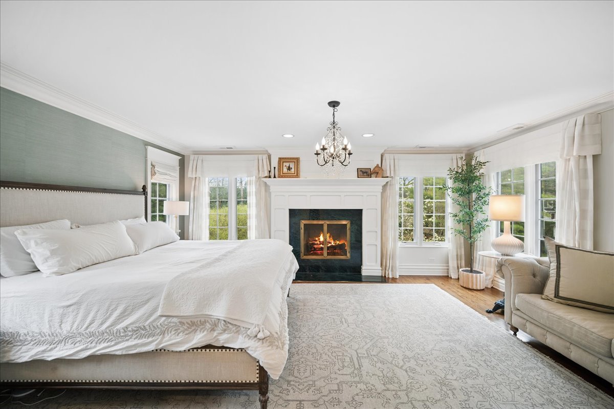 556 Willow Road Winnetka, IL 60093 - Photo 22 of 43 a spacious bedroom with a bed and a fireplace