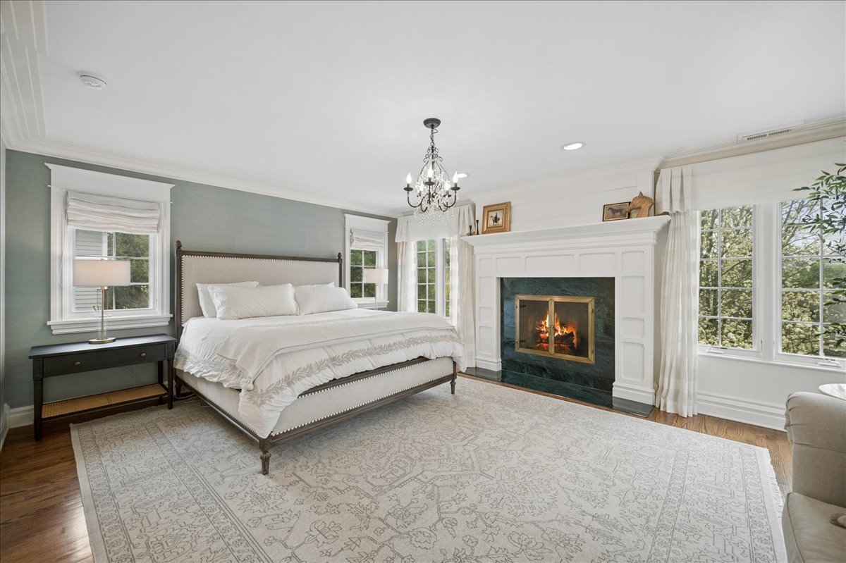 556 Willow Road Winnetka, IL 60093 - Photo 23 of 43 a spacious bedroom with a bed and a fireplace
