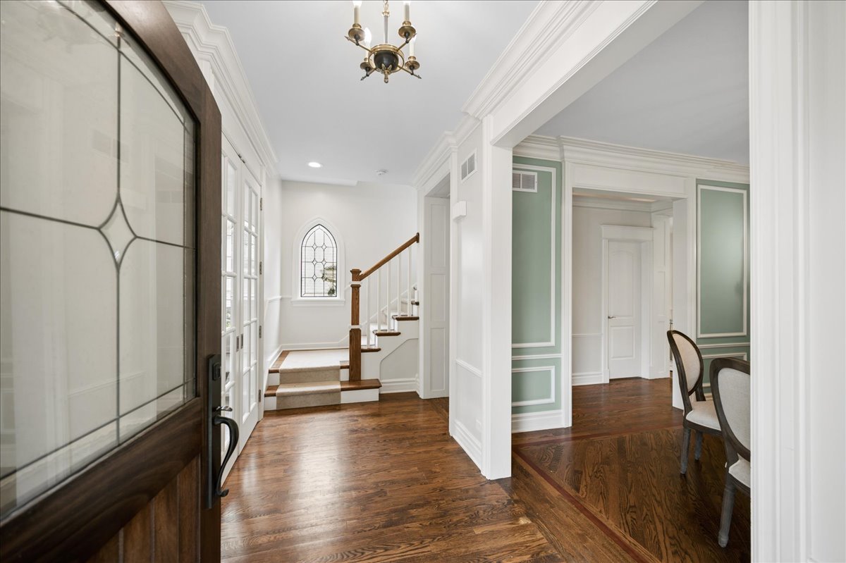 556 Willow Road Winnetka, IL 60093 - Photo 3 of 43 a view of a hallway with wooden floor and staircase