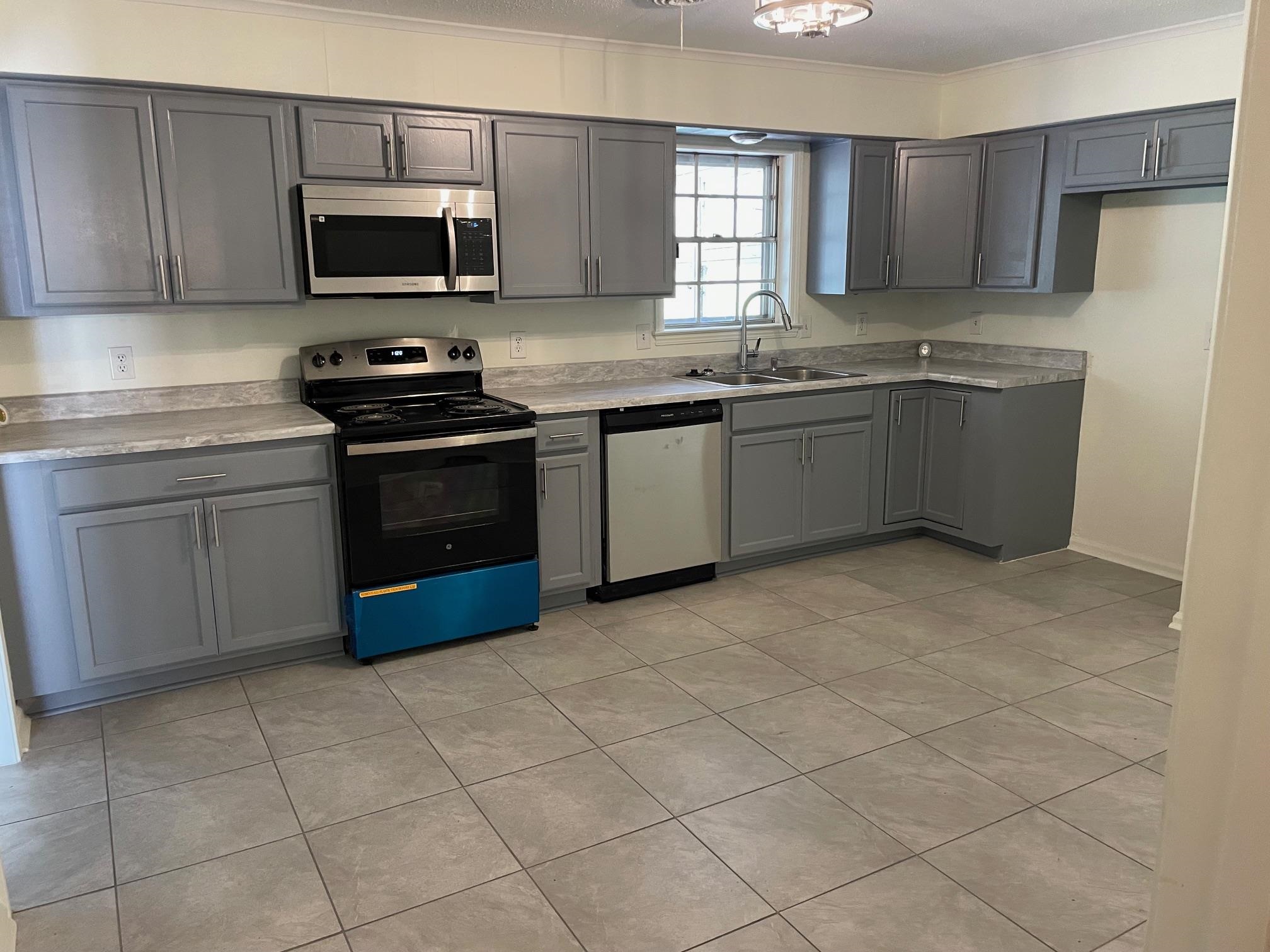 1898 Pennel Road Memphis, TN 38116 - Photo 8 of 34 a kitchen with stainless steel appliances a sink a stove a microwave a sink and cabinets
