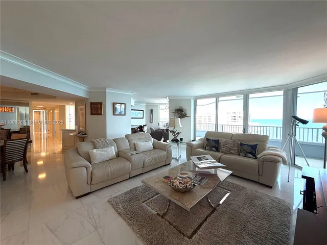 a living room with furniture potted plant and a large window